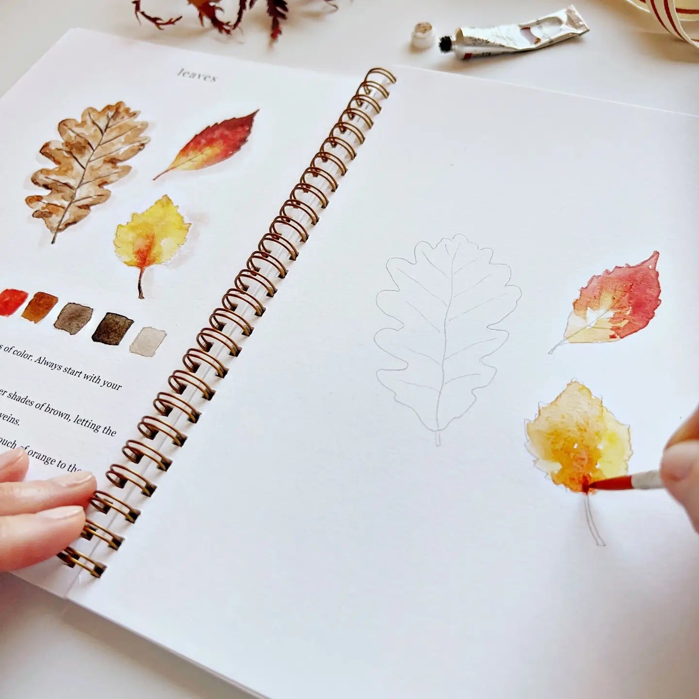 Inside view of someone painting yellow and red autumn leaves.