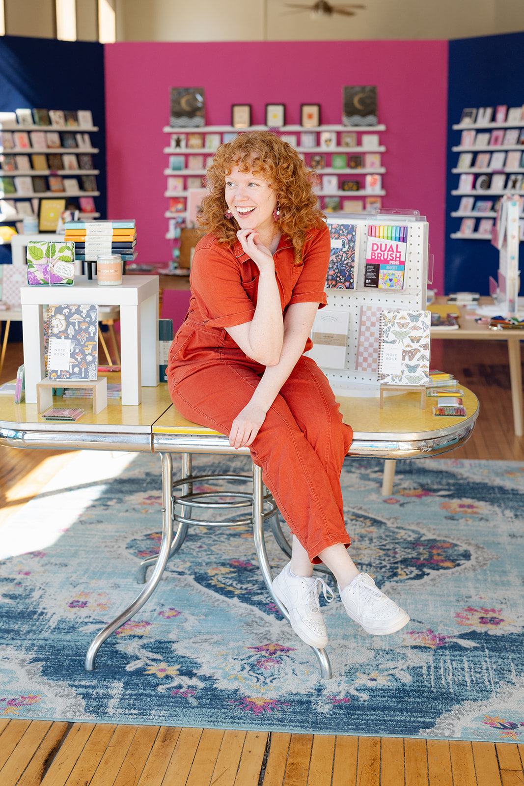 Person sitting on a table in front of a greeting card wall