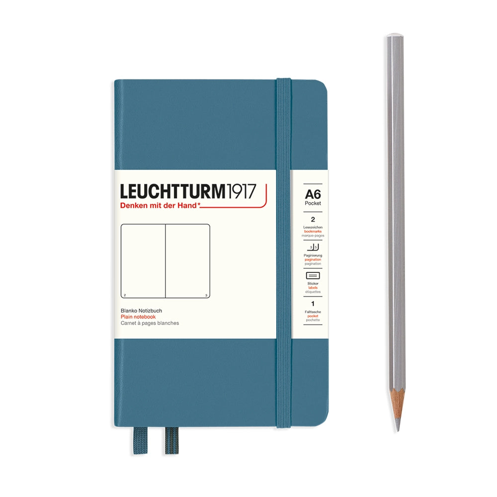 Blue notebook with white label and a silver pencil on a white background