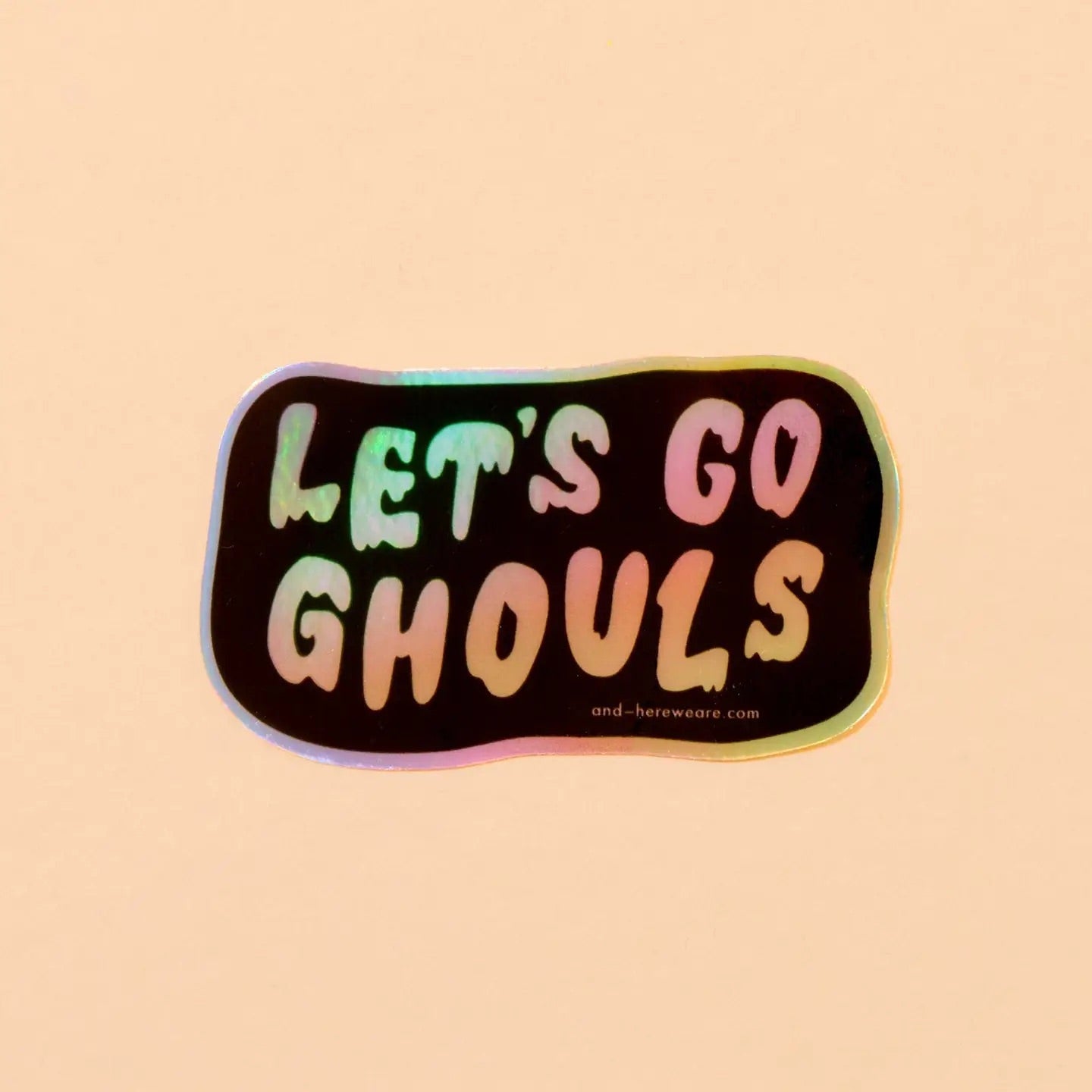 Holographic sticker with black background. Holographic text "let's go ghouls"