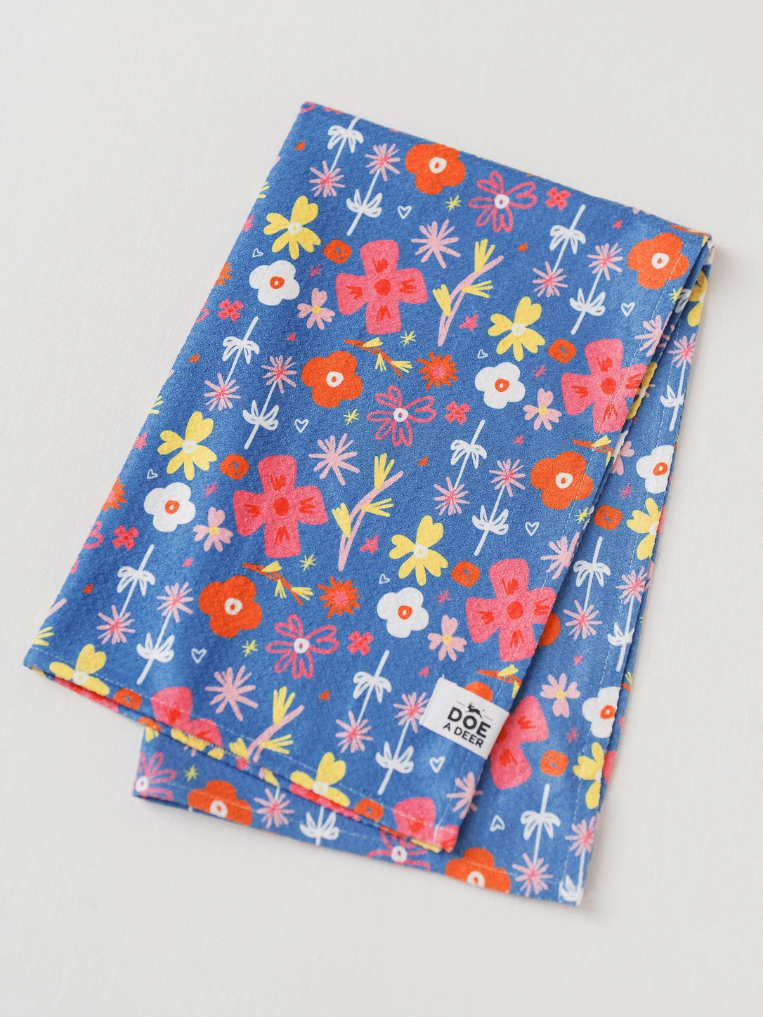 View of a blue microfiber towel with red, yellow, and white flowers