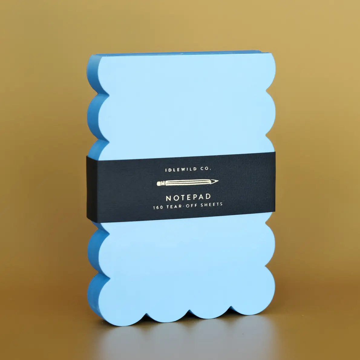 Blue scalloped notepad with a black band featuring 'Idlewild Co.' branding