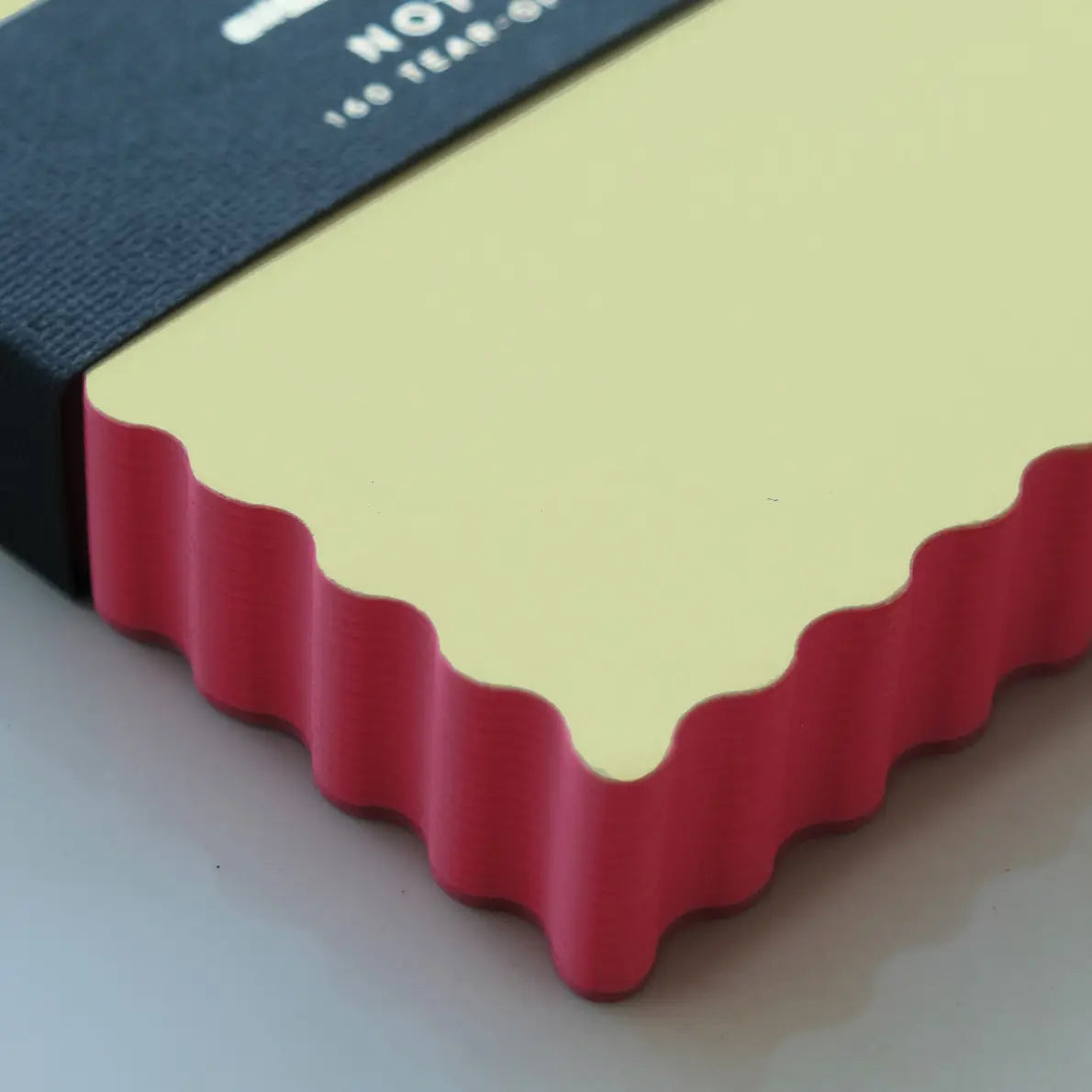 Close-up of notepad with a coral textured edge