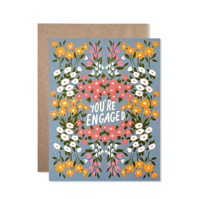 Greeting card with floral design and 'You're Engaged' text on a blue background, with a brown envelope.