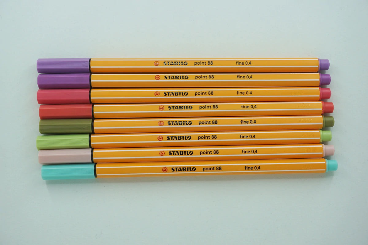 Pens with orange barrel and multicolor pen caps