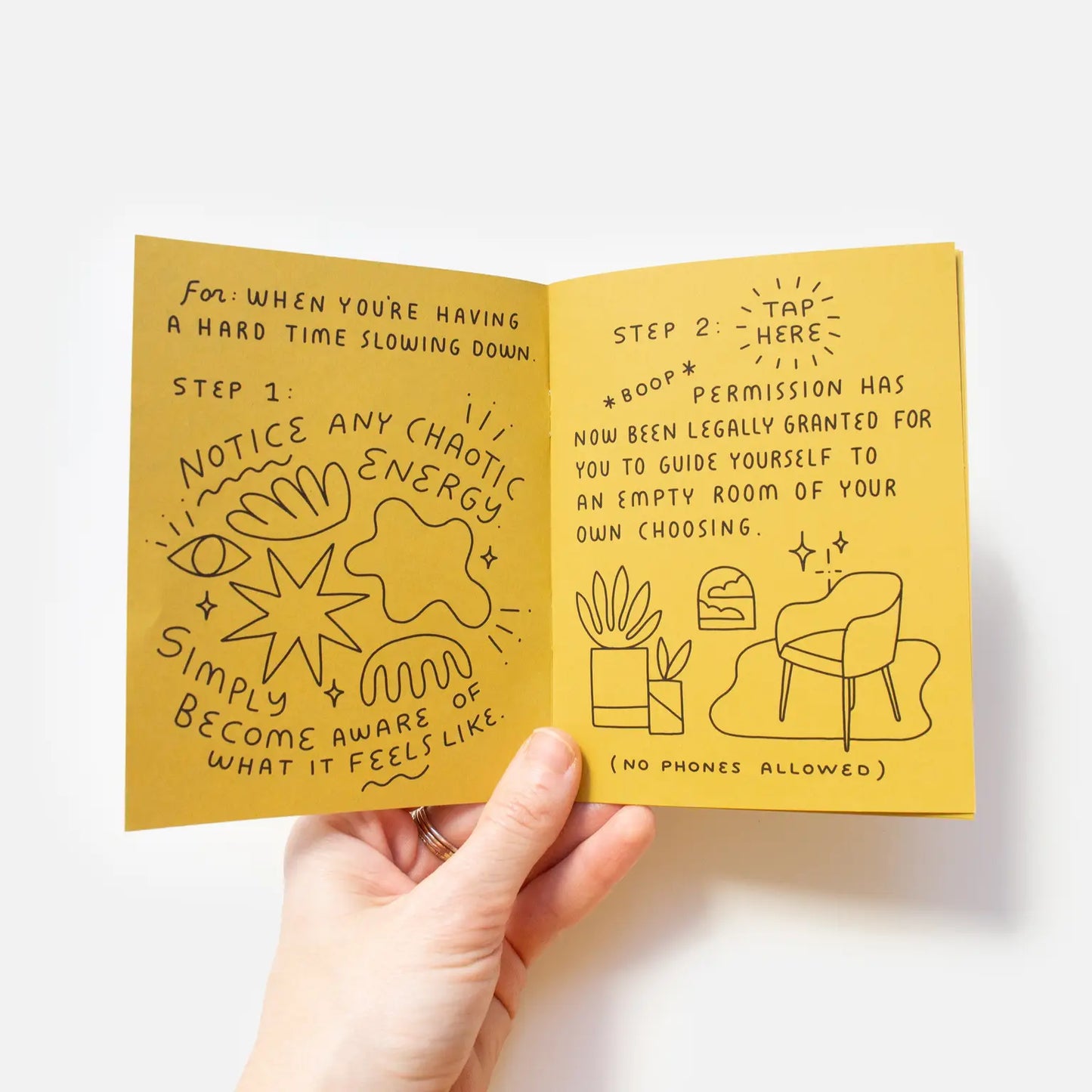 Inside look of booklet. Yellow pages. Black text reads "step one: notice any chaotic energy" and "step two: tap here, permission has now been legally granted for you to guide yourself to an empty room of your own choosing"