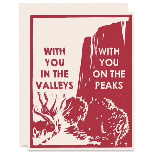 White greeting card. Brown design of a valley and mountain peak. Text reads "with you in the valleys, with you on the peaks" 