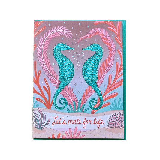 White card with full pink, red, turqouise color background. Illustration of two turquoise seahorses facing one another. "Let's mate for life" in red text. 