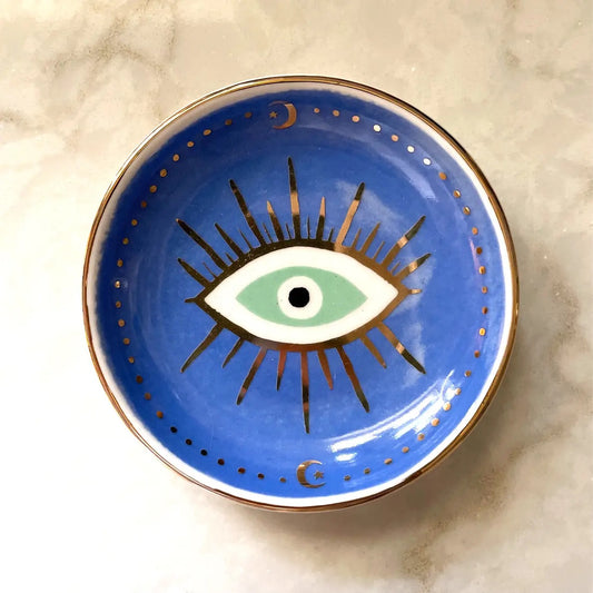 Circular dish with full-color blue background. White, gold, black, and green eye is painted in the middle of the dish. 