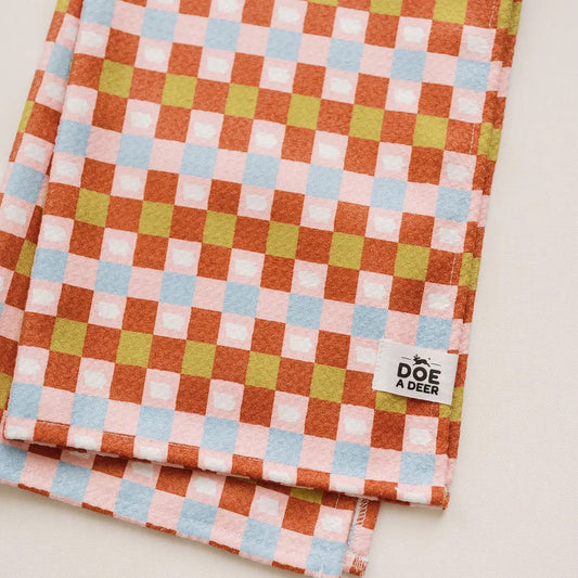 Front view of kitchen towel. Checkered design in brown, blue, pink, white, and lime green. 