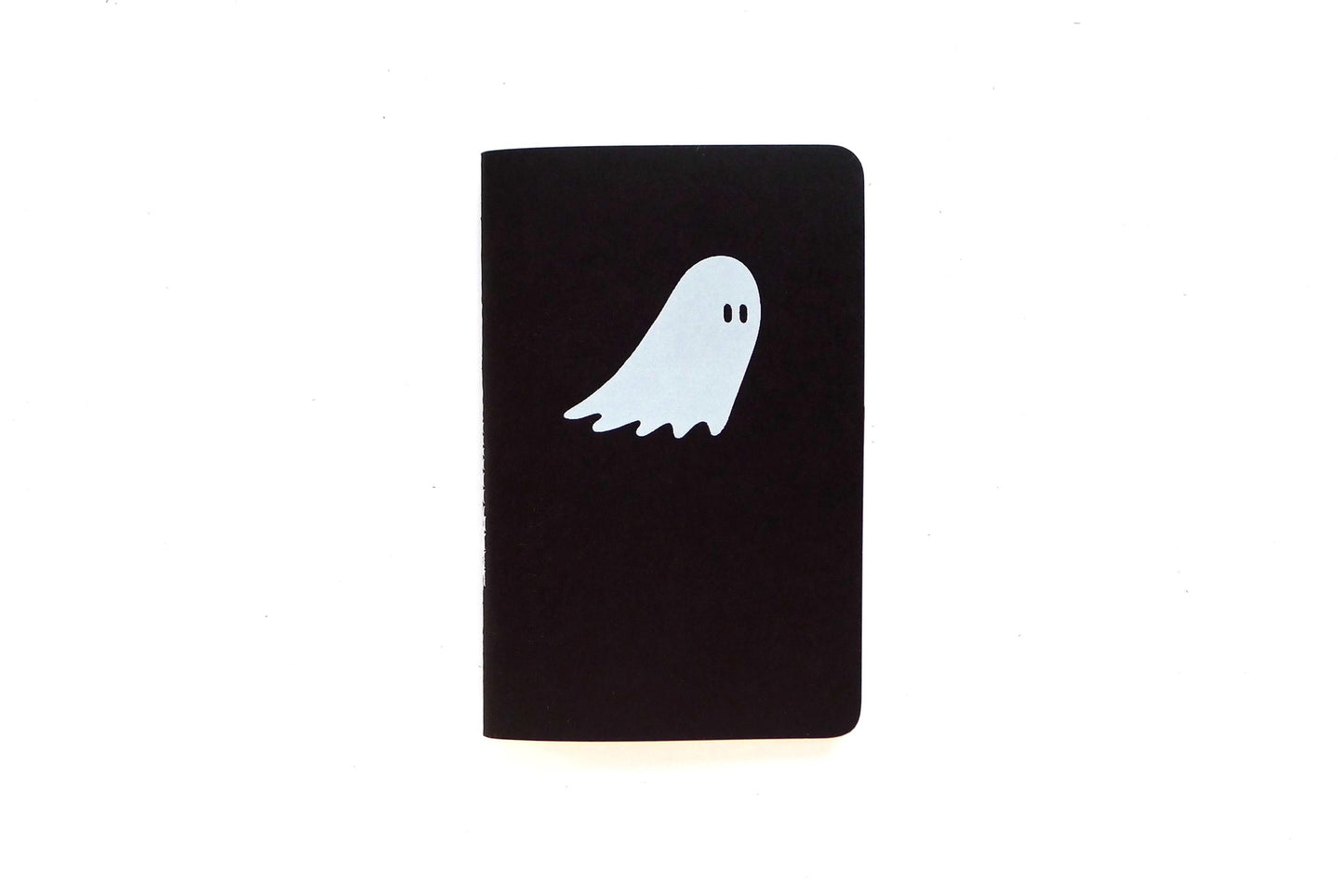 Front view of small black notebook. White ghost print on front cover. 