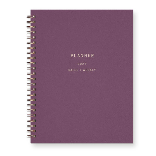 Front cover view of spiral-bound notebook. Plum color. "Planner, 2025, dated, monthly" is printed into the cover 