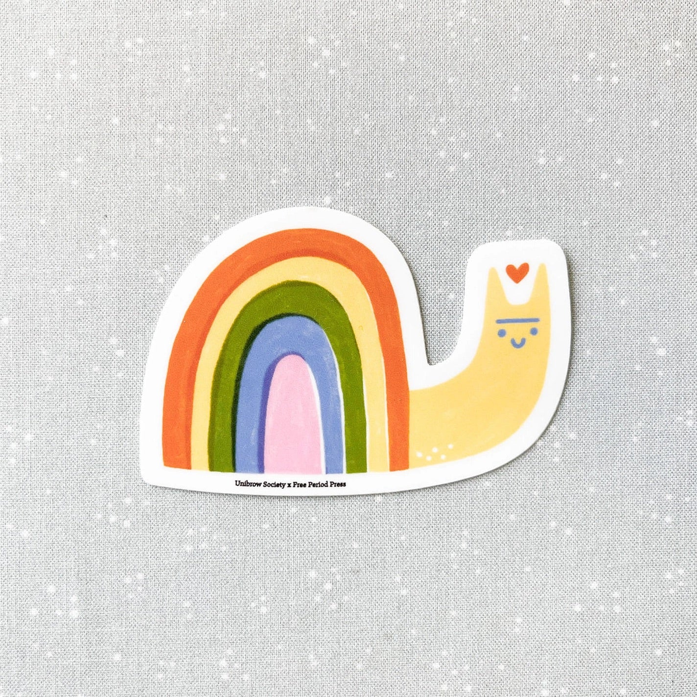 Die-cut sticker in the shape of a snail with a rainbow shell. 