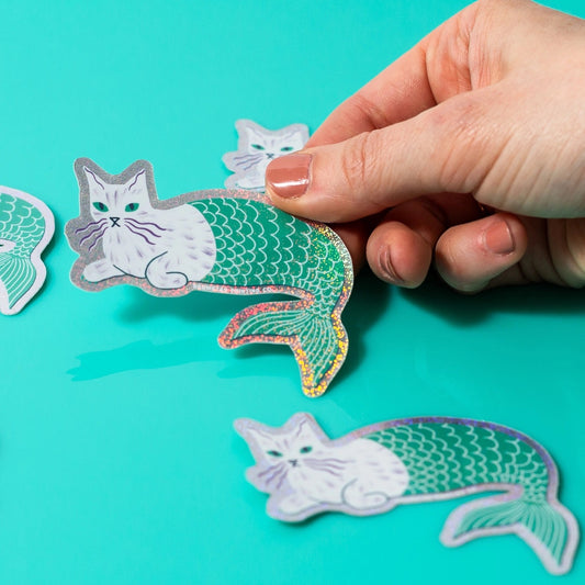 Hand holding a mermaid kitty sticker