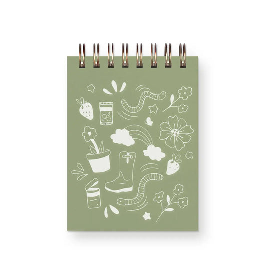 Front cover of top-spiral notebook. Green color with white garden illustrations 