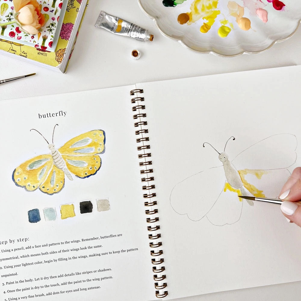 Inside view of watercolor workbook showing a butterfly painting 