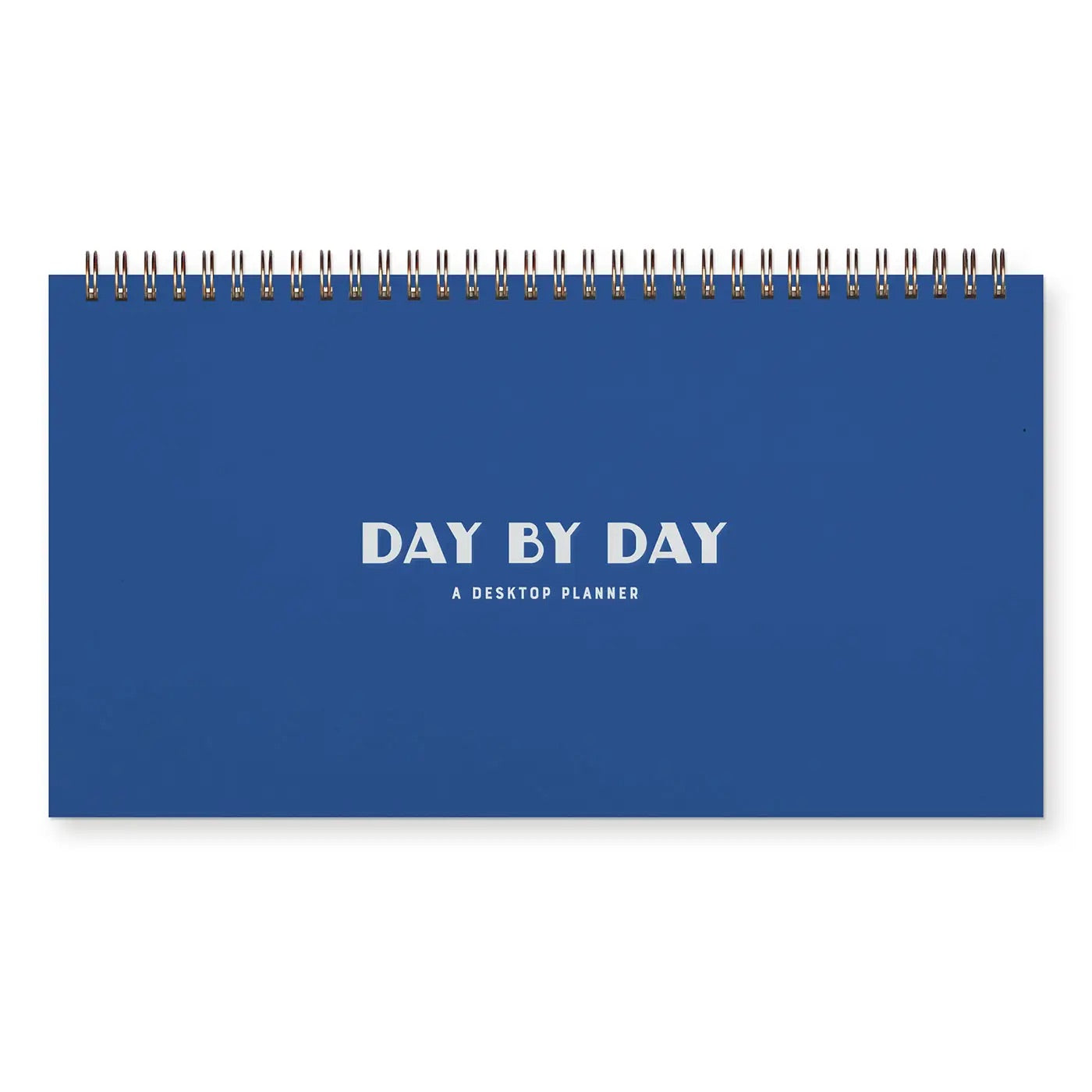 Front cover of top-spiral planner. Blue cover with white text “day by day”