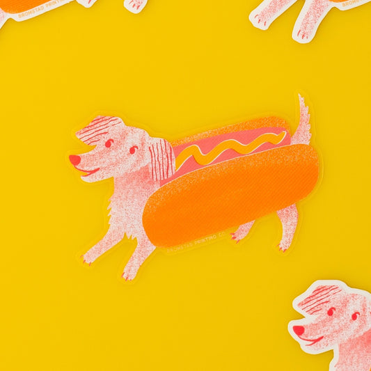 Die-cut sticker in the shape of a dog wearing a hot dog costume