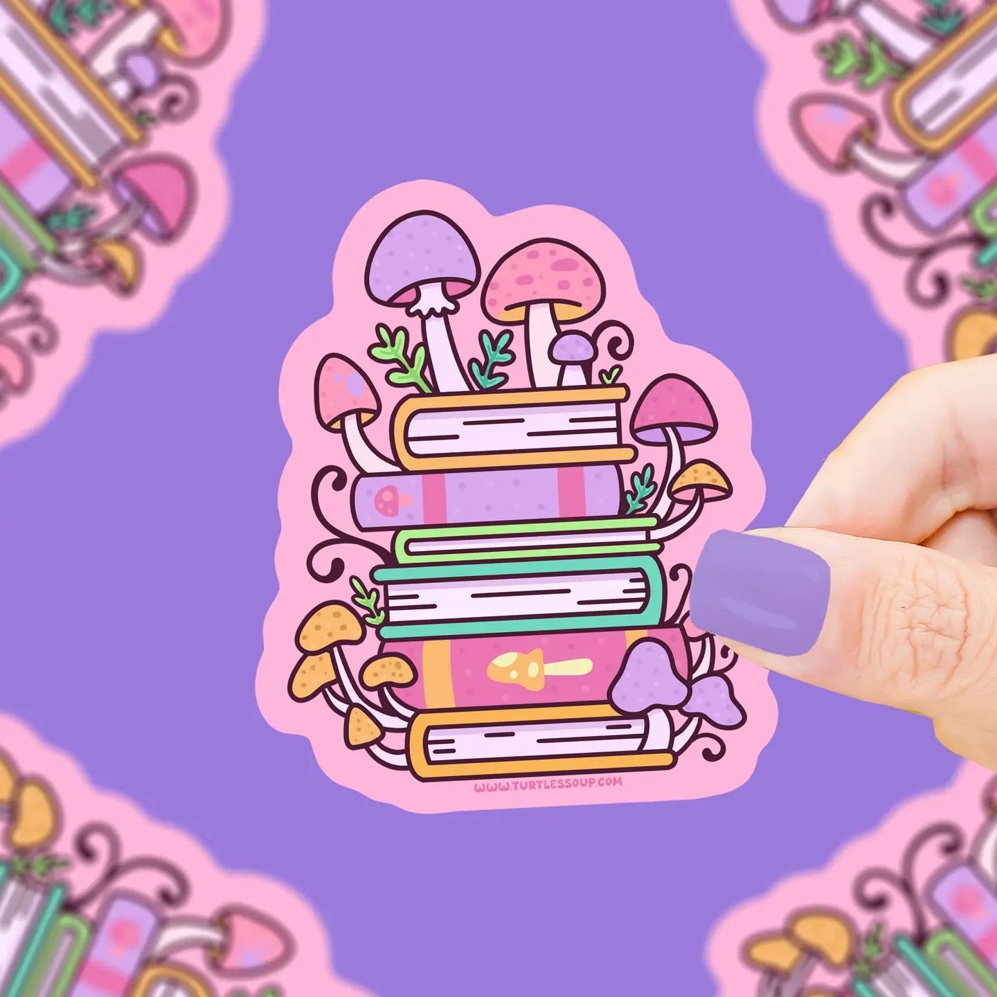 Hand holding a die-cut sticker. Illustration on the sticker is of a stack of books with mushrooms growing on top of them. Sticker is pastel pink, orange, and purple colors. 