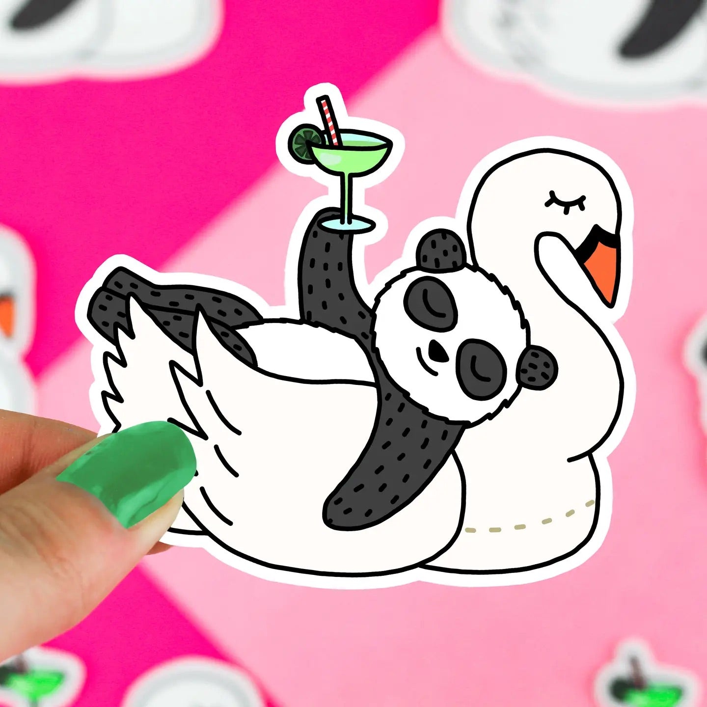 Hand holding a die-cut sticker in the shape of a black and white panda lying down on a swan shaped pool float. Illustration panda is holding green drink with a straw in it.