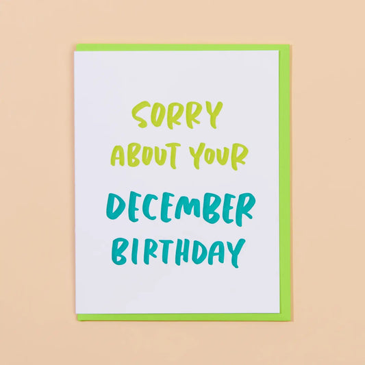 White card with neon green lettering. Text “sorry about your December birthday” 