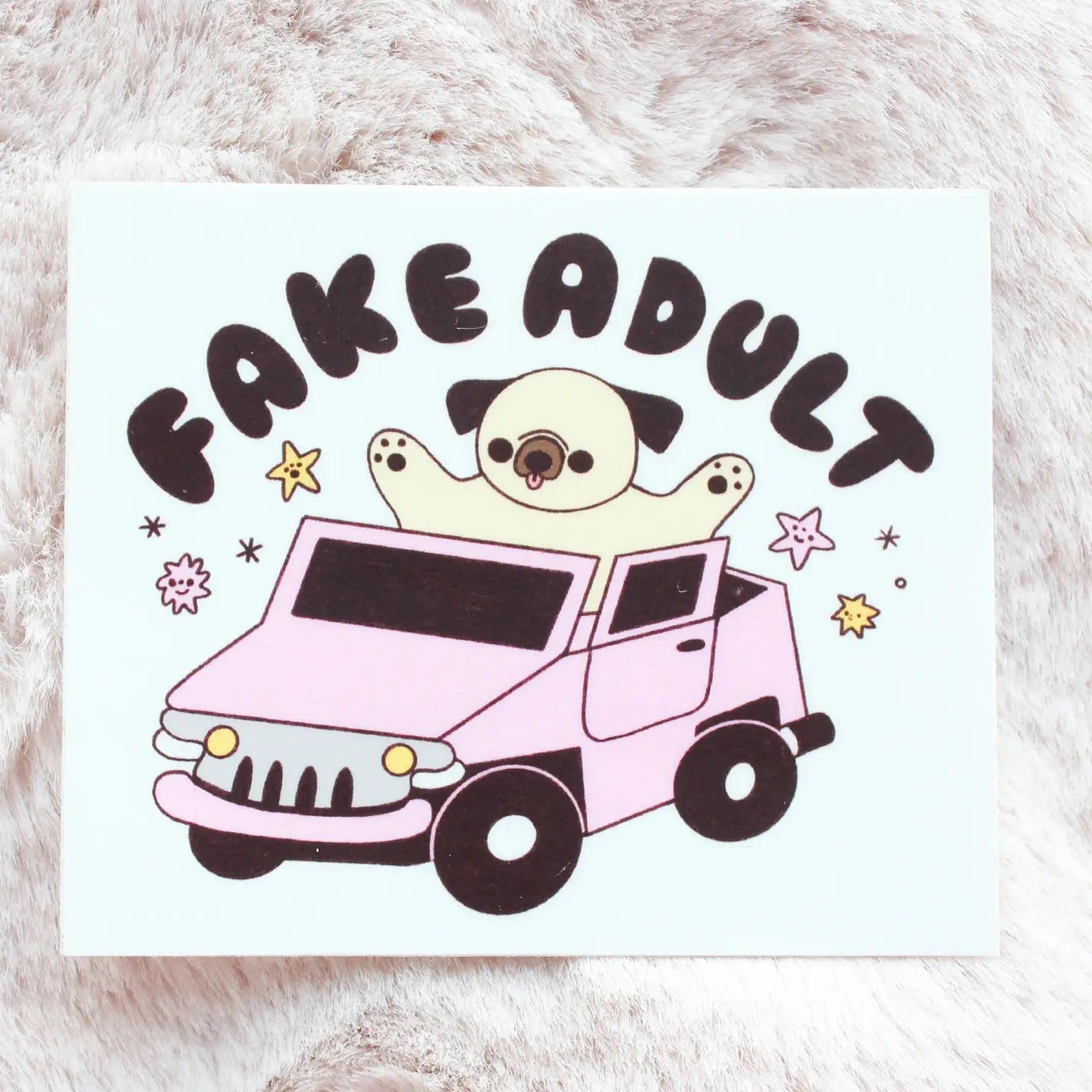 Rectangle-shaped white sticker with an illustration of a dog in a car. "Fake adult" in black text. 