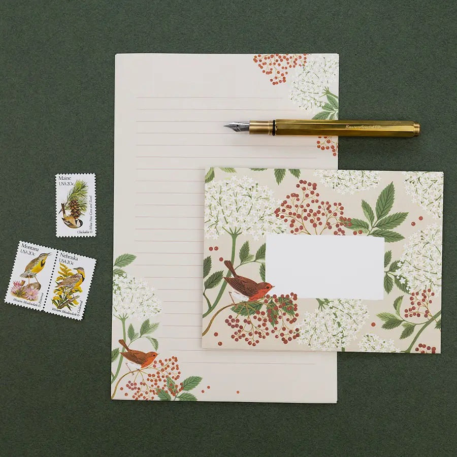 Flat lay of paper, envelope, stamps, and pen 