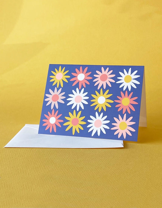 White greeting card with full color blue background. Multicolor daisy illustration 