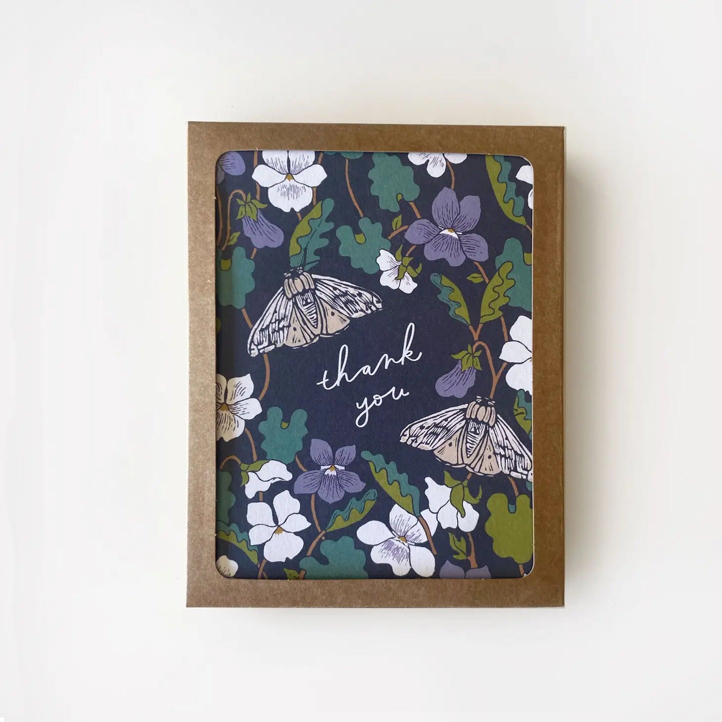 White thank you card with full color navy background. Purple, green, and white floral design. “Thank you” in white text 