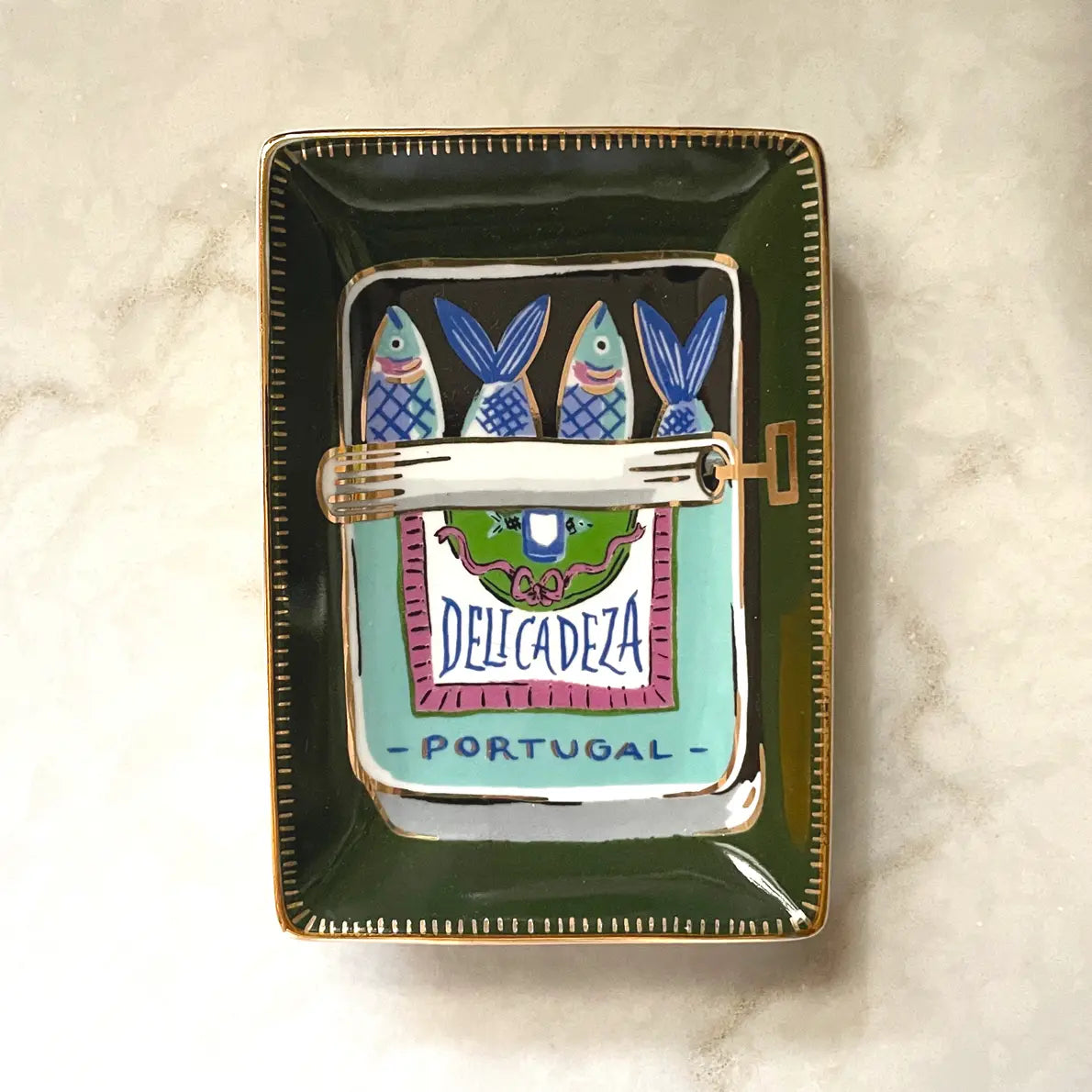 Rectangular dish with dark green background. Interior painting of blue, green, red and white sardines tin