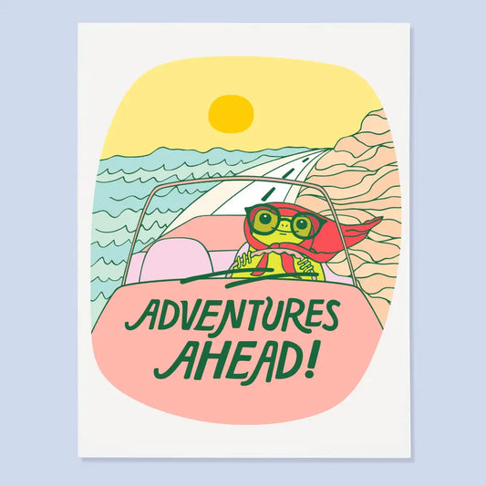 White greeting card featuring an illustration of a frog driving a car with 'Adventures Ahead!' text, set against a beach scene.
