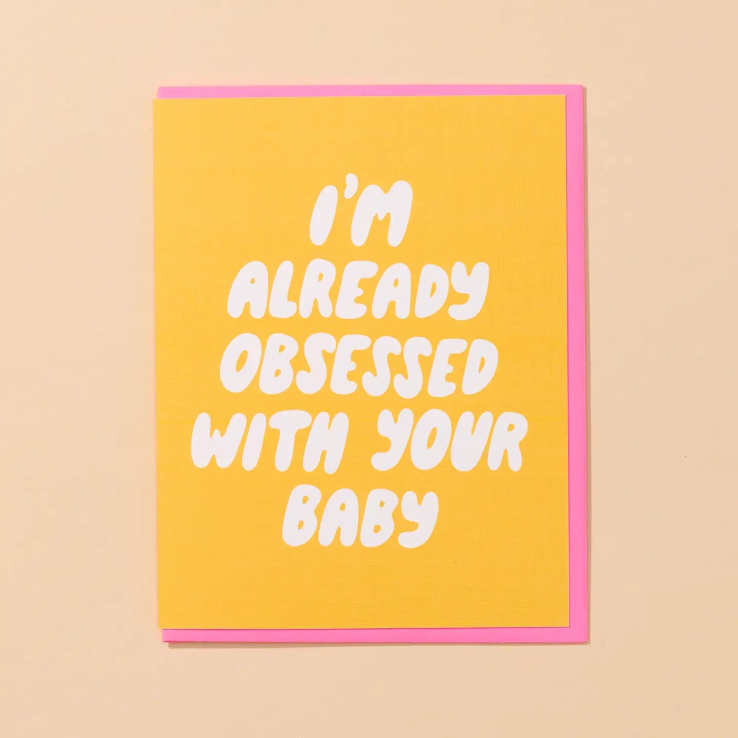White greeting card with full color yellow background. White bubble text: I’m already obsessed with your baby 