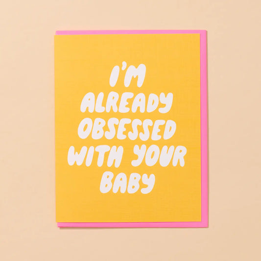 White greeting card with full color yellow background. White bubble text: I’m already obsessed with your baby 