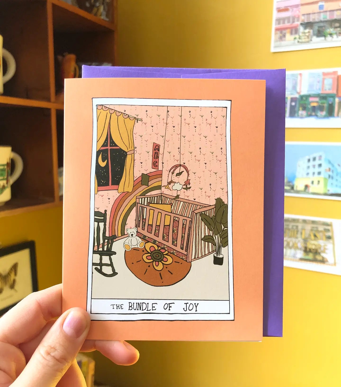 Greeting card with tarot-inspired design of a nursery. Text: the bundle of joy 