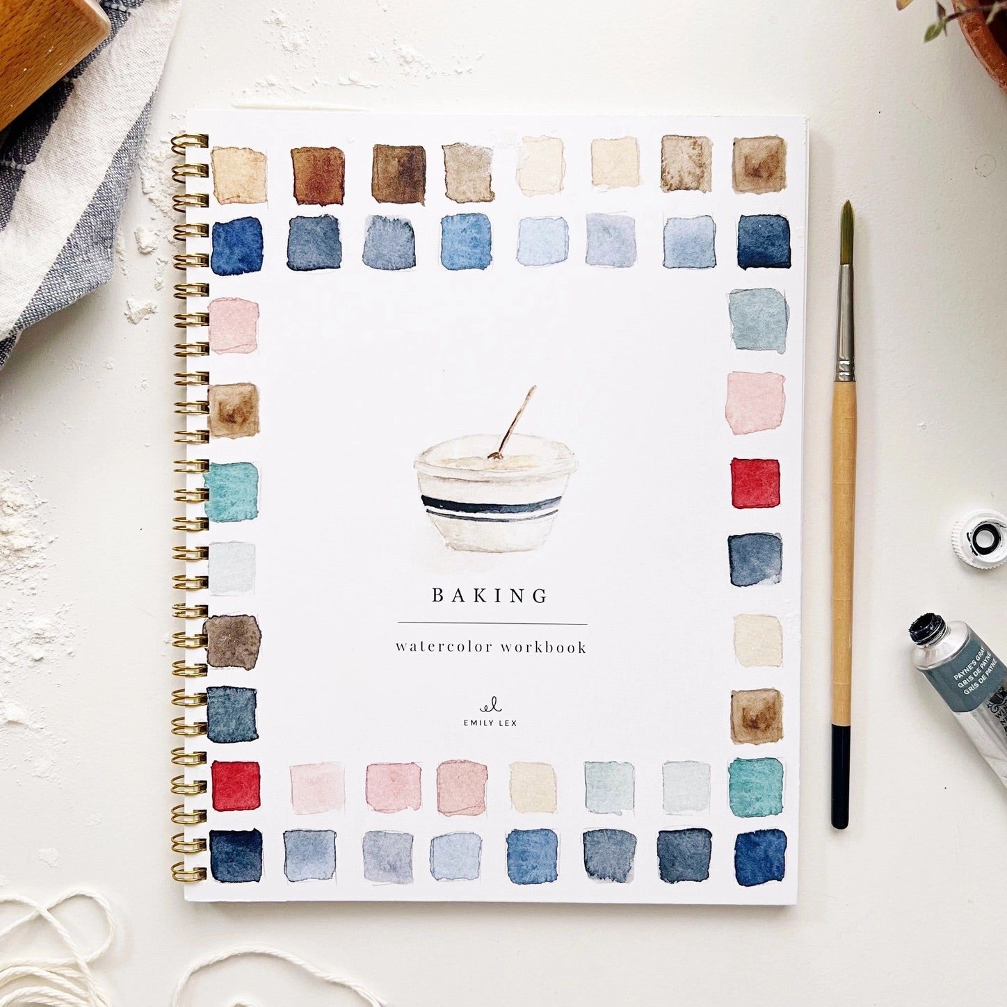 Spiral-bound watercolor workbook with white cover and a baking bowl painting. Black text reads "baking watercolor workbook." 