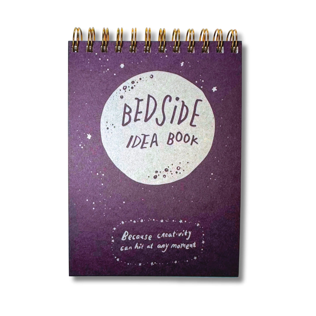 Purple top spiral notebook titled 'Bedside Idea Book' with a moon design