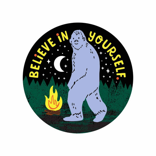 Round sticker with a Bigfoot and campfire illustration. 'Believe in Yourself' text against a black background.