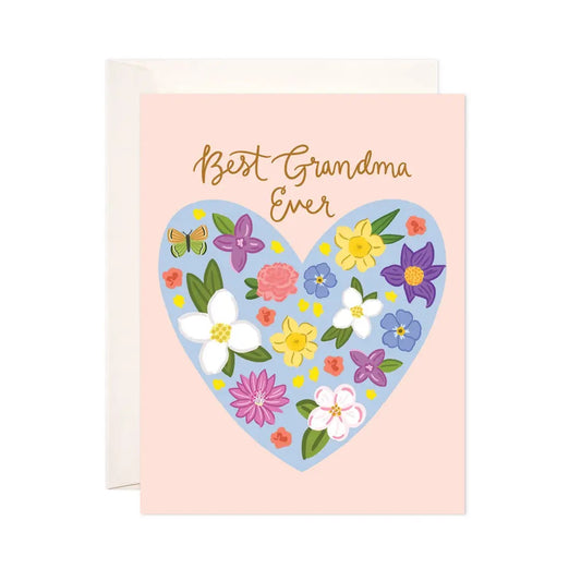 White greeting card with full color light pink background. Illustration of a heart filled with colorful flowers. Gold text: best grandma ever 
