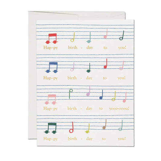White greeting card featuring music notes for happy birthday song 