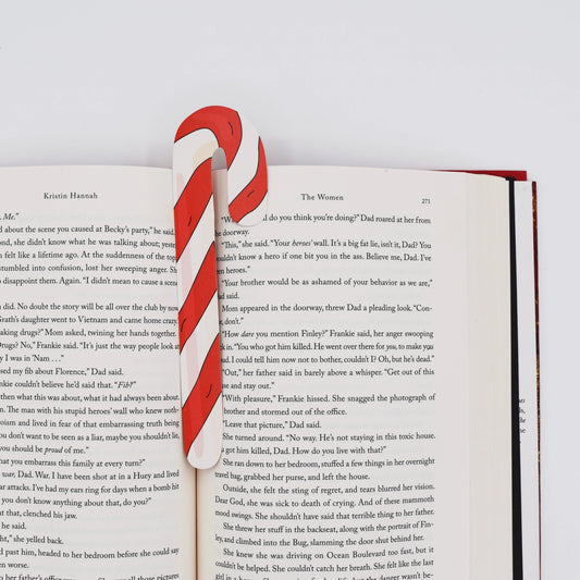 Candy cane bookmark on an open book with a white background