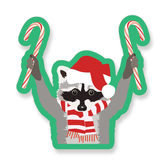 Did-cut sticker of a raccoon wearing a Santa hat and scarf and holding candy canes.