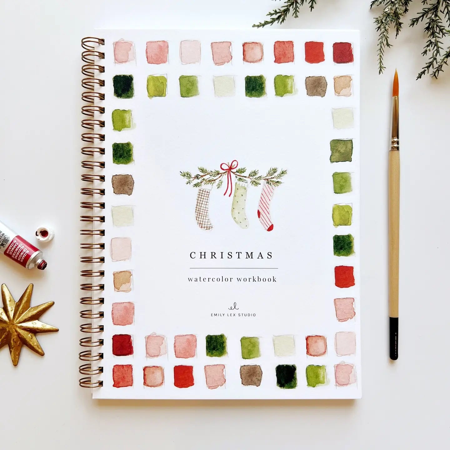 Front cover of a Christmas watercolor workbook with painting of stockings 