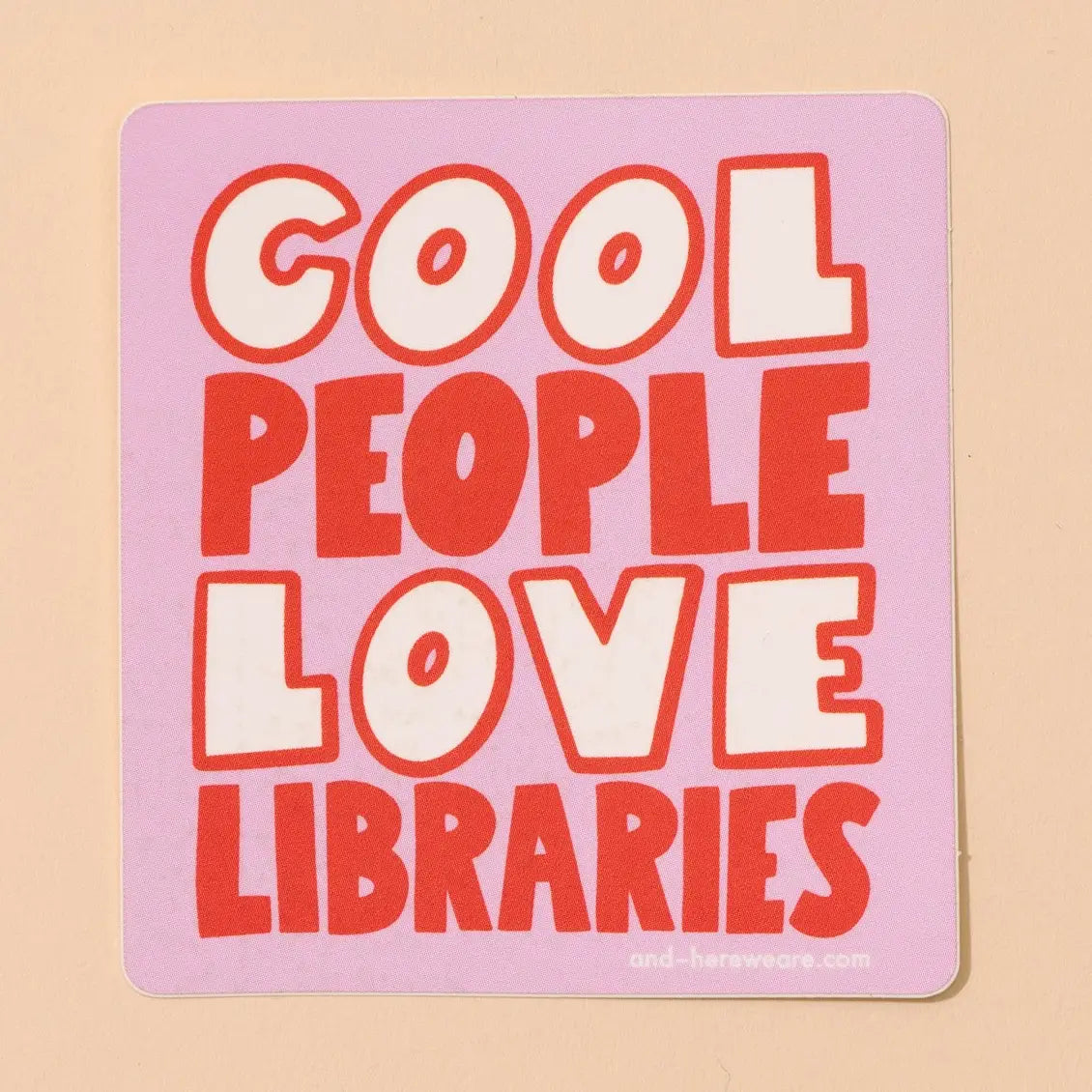 Pink, red, and white sticker with 'Cool people love libraries' text on a beige background