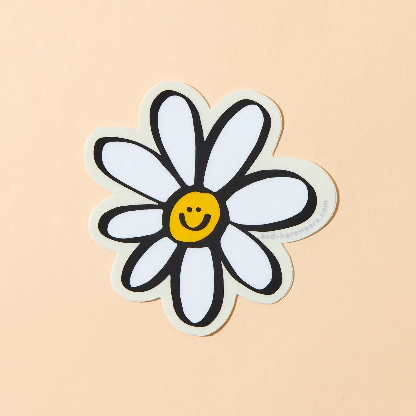 A vinyl sticker of a happy daisy with a smiling face on a light background.