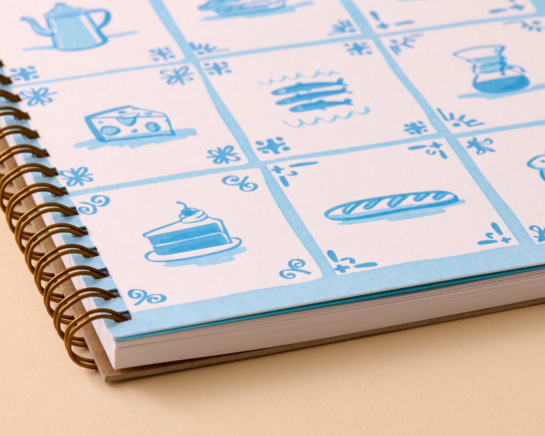 Notebook with blue and white illustrated cover on a beige surface