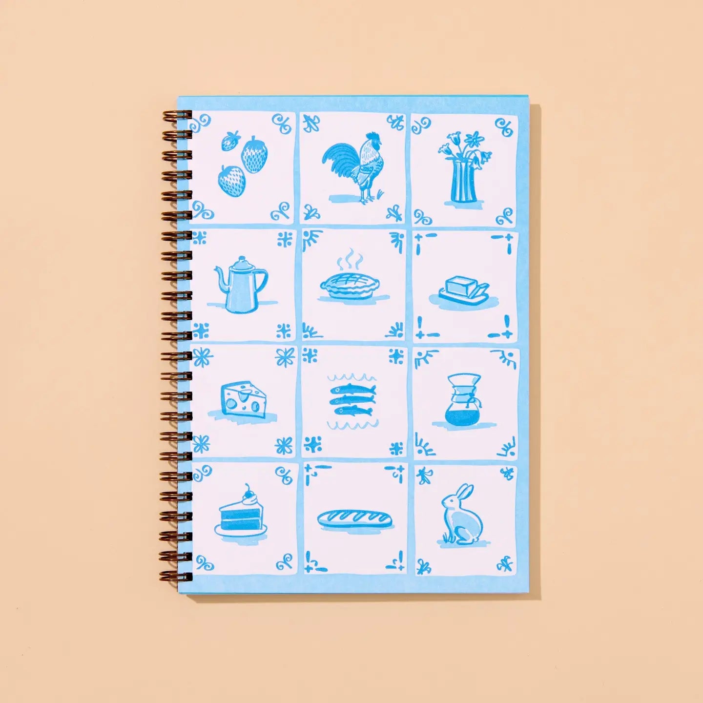 Notebook with blue delft tile illustrations on a beige background