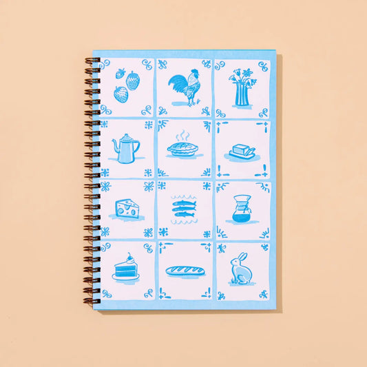 Notebook with blue delft tile illustrations on a beige background