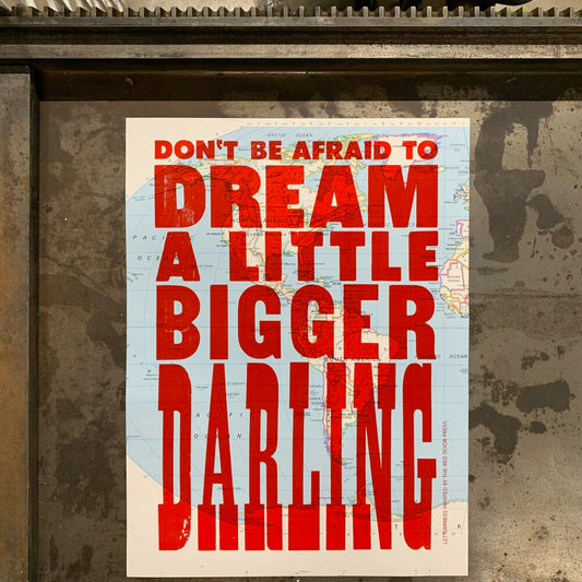 Vintage map with text printed in red ink: don’t be afraid to dream a little bigger darling 