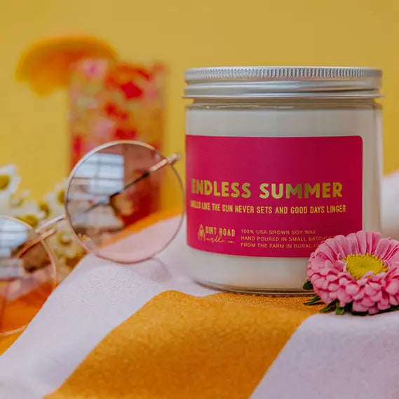 Candle jar labeled 'Endless Summer' on a colorful background with flowers and sunglasses.
