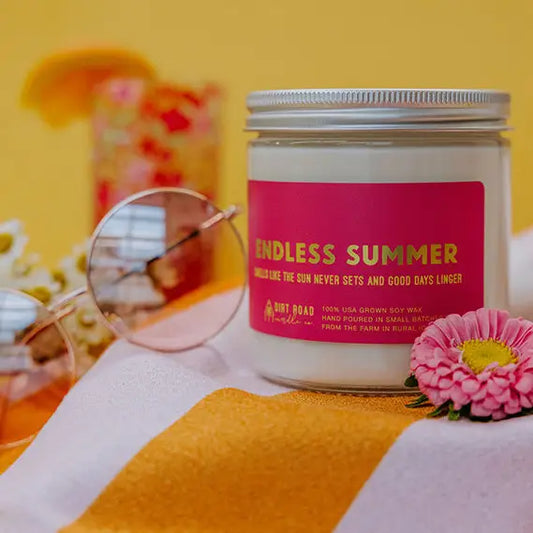 Candle jar labeled 'Endless Summer' on a colorful background with flowers and sunglasses.